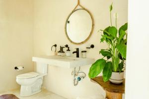 a bathroom with a sink and a mirror and a toilet at Jungle Tiny Home Retreat - Casa de Seda in Chemuyil +44 photos