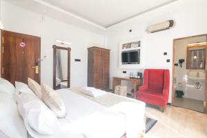 a bedroom with a white bed and a red chair at Twin Villa Red - Luxury Villa with Mountain View in Nuwara Eliya