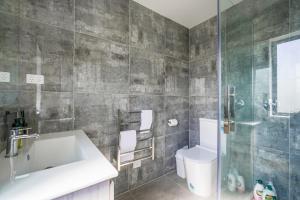 a bathroom with a sink and a toilet and a shower at Lovely 3-BR Home in Long Bay Near Beaches & Albany in Auckland +24 photos