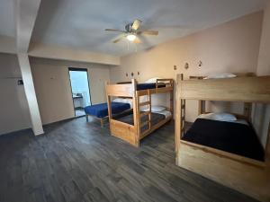 Una habitación con dos literas y un ventilador de techo. en La Casa del Mercado, en San Miguel de Allende 60 fotos más