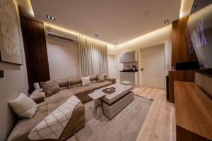 a living room with a couch and a table at Ohud Suites - أجنحة أحد in Riyadh +36 photos
