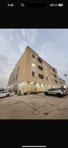 a large building with cars parked in front of it at Ohud Suites - أجنحة أحد in Riyadh