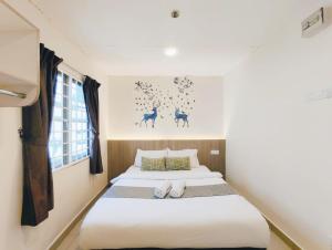 a bedroom with two beds and a painting on the wall at SCC Gateway Chinatown Hotel in Kuala Lumpur