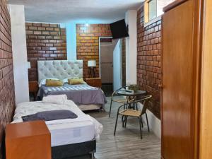 una camera da letto con due letti e un tavolo di Hotel Nuestro Amo a Sayán Altre 25 foto