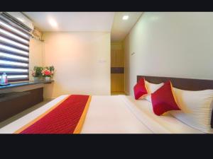 une chambre avec un lit avec des oreillers rouges et blancs dans l'établissement Green Park Residency, à Ramanathapuram