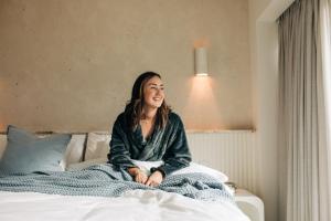 a woman sitting on top of a bed at Rumi On Louth in North Shields