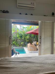 Un dormitorio con vista a una piscina a través de la puerta. en Villa Harmony Moon, en Denpasar