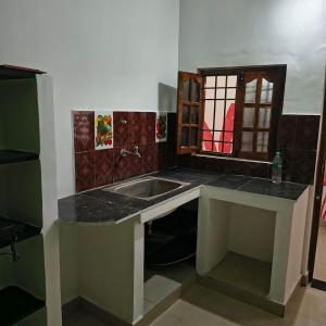une cuisine avec un évier et un plan de travail dans l'établissement Thamara Auroville Homestay, à Pondichéry 13 autres photos