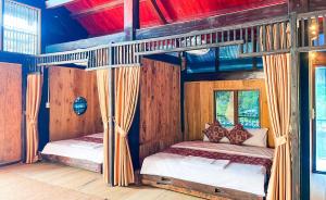 Dos camas en una habitación con paredes de madera. en HaGiang Go Ecolodge, en Làng Lap 79 fotos más