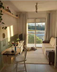 a living room with a desk and a bed and a window at Intan Vallez Apart in Jambi