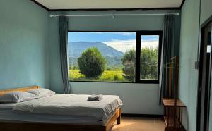a bedroom with a bed and a large window at sokxay guesthouse in Vang Vieng +5 photos