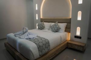 a bedroom with a large white bed with a headboard at Cavahills Cottage in Denpasar