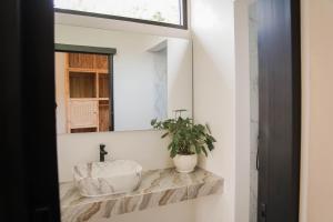 a bathroom with a sink and a mirror at Cavahills Cottage in Denpasar +28 photos
