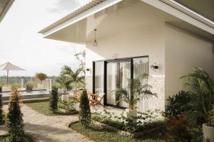 a white house with a courtyard with plants at Cavahills Cottage in Denpasar