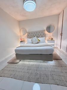 - une chambre blanche avec un grand lit et un tapis dans l'établissement Silhouette 19 luxury, à Margate