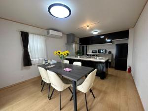 een keuken en eetkamer met een tafel en stoelen bij 波音ハウス in Yugawara