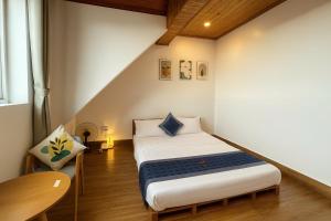 une petite pièce avec un lit et une chaise dans l'établissement Cosy Hotel & Apartment Dalat, à Đà Lạt