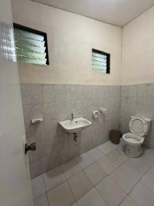 a bathroom with a toilet and a sink at Casa Fleur in Cangalwang