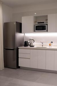a kitchen with a stainless steel refrigerator and a sink at Vizion Juncal- Encanto francés en el corazón de Recoleta- Wifi alta velocidad-Seguridad 24 horas in Buenos Aires