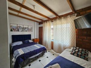 una camera da letto con due letti e una finestra di Hotel Nuestro Amo a Sayán