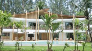 a resort with a swimming pool and palm trees at The TALAY in Ban Na Tai
