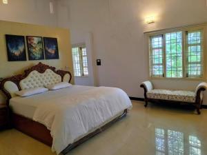 une chambre avec un lit, un canapé et des fenêtres dans l'établissement Yercaud Bungalow Stay, à Yercaud