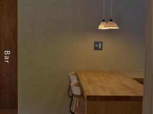 a dining room with a wooden table and a light at and farmクラインガルテン in Nirasaki