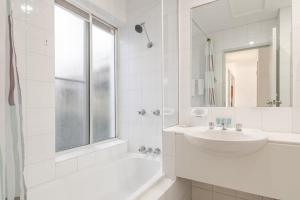 a white bathroom with a sink and a bath tub at Quarterdeck Unit 2 - Lennox Head in Lennox Head
