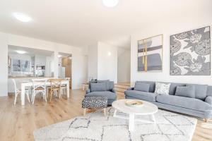 a living room with a blue couch and a table at Quarterdeck Unit 2 - Lennox Head in Lennox Head +7 photos