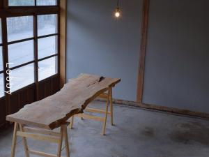 a wooden table in a room with a window at and farmクラインガルテン in Nirasaki