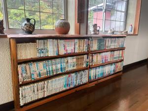 een boekenplank gevuld met veel dvd's bij Guesthouse PAW in Nagano