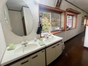een badkamer met een wastafel en een spiegel bij Guesthouse PAW in Nagano +9 foto's