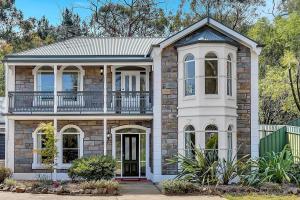 a large brick house with a balcony at The Alderstone - Serene Haven in the Adelaide Hills in Aldgate