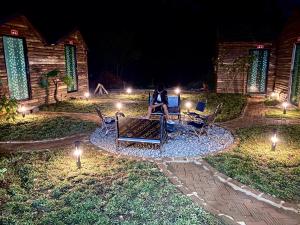a woman sitting on a bench in a yard at night at Homestay26 in Bắc Yên +9 photos