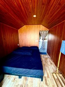 a bedroom with a bed in a wooden room at Homestay26 in Bắc Yên