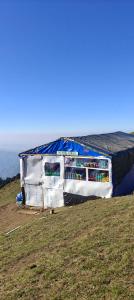 a house with a roof on top of a hill at The Royal Roast in Shoja