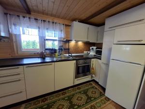 a small kitchen with white appliances and a window at Mounty vendégház in Borzont