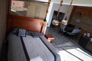 a bedroom with a bed in a room with a table at Rancho Valsan Cabaña El Tiro in El Oro de Hidalgo