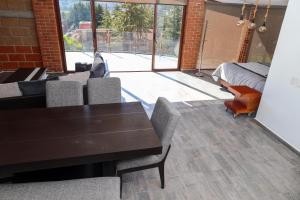 a dining room with a table and chairs and a large window at Rancho Valsan Cabaña El Tiro in El Oro de Hidalgo +9 photos
