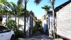塞米亚克Tahoma Villas Seminyak by ABM的一条种有棕榈树和白色汽车的街道