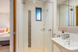 ein Badezimmer mit Dusche, Waschbecken und Spiegel in der Unterkunft Sandy Feet in Lennox Head + 12 Fotos