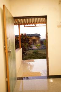 an open door with a view of a house at Gir Moonlight Farm in Sāsan Gīr