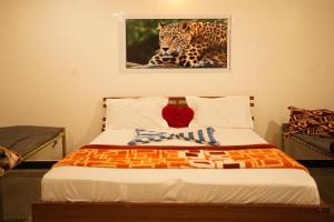 a bedroom with a bed with a picture of a leopard at Gir Moonlight Farm in Sāsan Gīr
