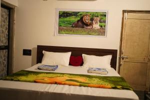 a bedroom with a bed with a picture of a lion at Gir Moonlight Farm in Sāsan Gīr
