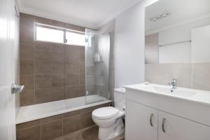 a white bathroom with a toilet and a sink at Conjola Escapes in Green Island +10 photos