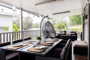 a screened porch with a table and chairs at Conjola Escapes in Green Island