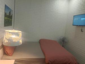 Habitación con cama, lámpara y TV. en Dandelion Home 24C Dalat, en Xuan An