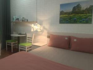 Un dormitorio con una cama y una mesa y una mesa y una silla. en Dandelion Home 24C Dalat, en Xuan An