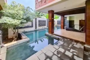 an infinity pool in the backyard of a house at Urbanview Hotel Syariah SieKemboe Near Alun-Alun Jepara in Kesembu