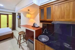 a kitchen with a sink and a bed in a room at Urbanview Hotel Syariah SieKemboe Near Alun-Alun Jepara in Kesembu